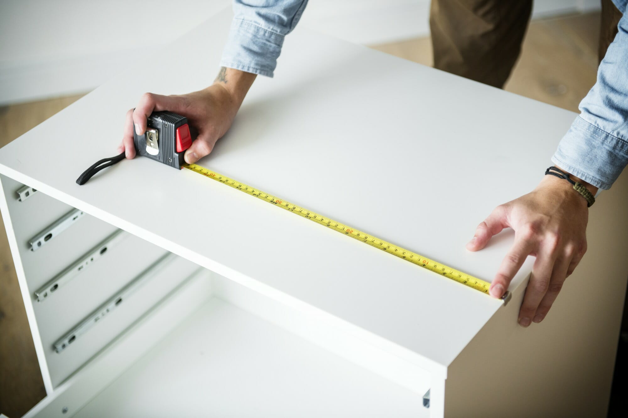 man-measuring-the-cabinet made to measure kitchen cabinet